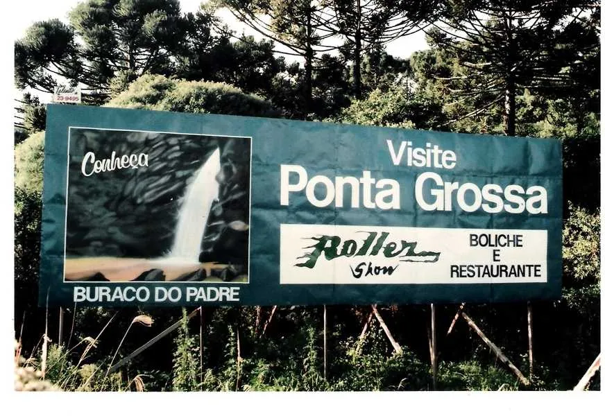 Aqui cartaz patrocinado pela “Roller Show”. A placa promovia a visita ao  “ Buraco do Padre.” Foi feita  pela Talento, e a foto deve ser do  Domingos Souza do Foto Elite.
