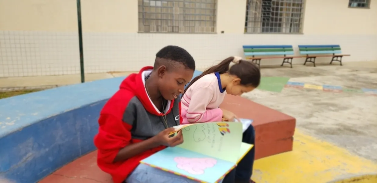 Erikson Maria dos Santos, 11 anos, e Elisana de Paula, 09, formam dupla onde um aluno faz a leitura e ajuda a melhorar a prática do colega