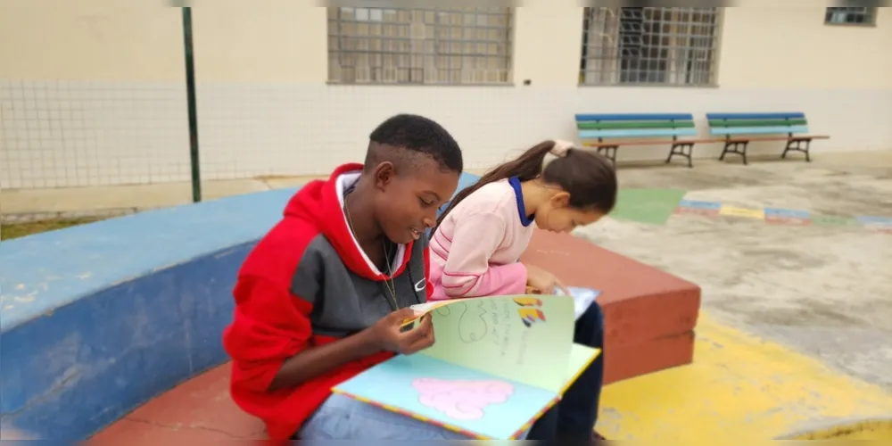 Erikson Maria dos Santos, 11 anos, e Elisana de Paula, 09, formam dupla onde um aluno faz a leitura e ajuda a melhorar a prática do colega