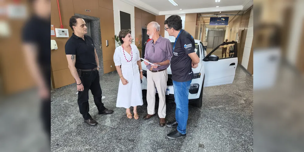 Elizabeth Schmidt entrega prêmio ao ganhador João Luiz