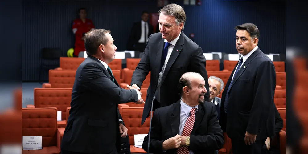Mauro Cid cumprimentando Jair Bolsonaro, durante depoimento dos réus