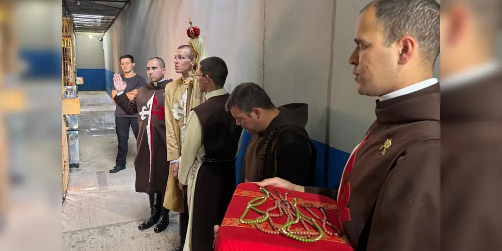 Membros dos Arautos do Evangelho apresentando a imagem de Nossa Senhora de Fátima aos detentos