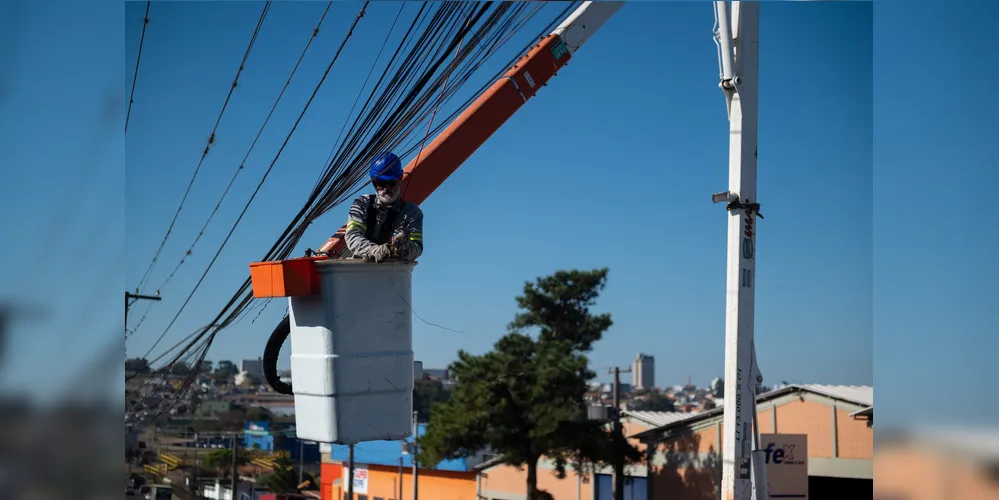 Funcionários da Copel fazem a retirada de fios sem utilidade dos postes no bairro Santa Paula.